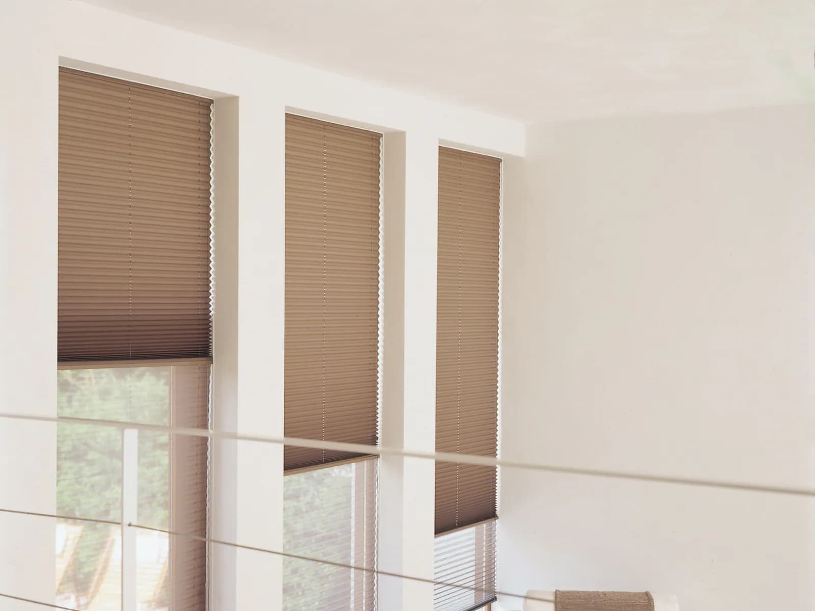 Wohnraum mit Plissees an hohen Fenstern, maßgefertigt von ROOMSCRAFT